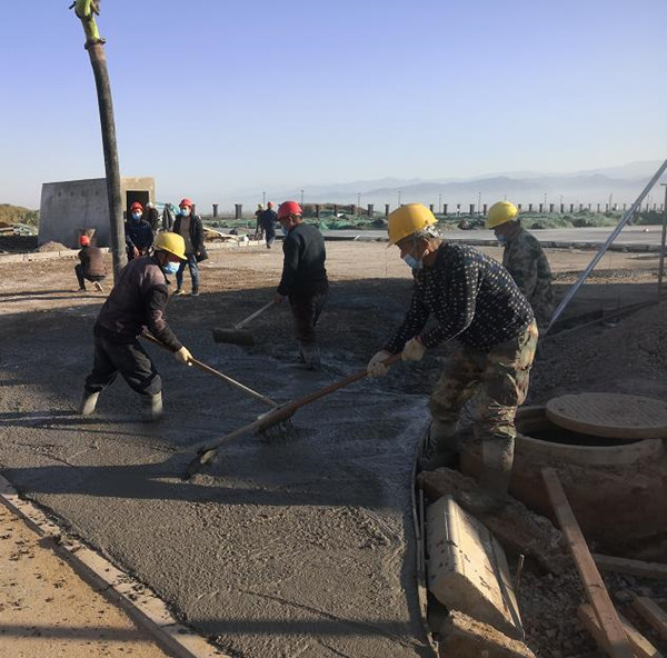 寶雞蟠龍新區污水處理廠項目施工人員對廠區道路面層進行混凝土澆筑作業_副本.jpg